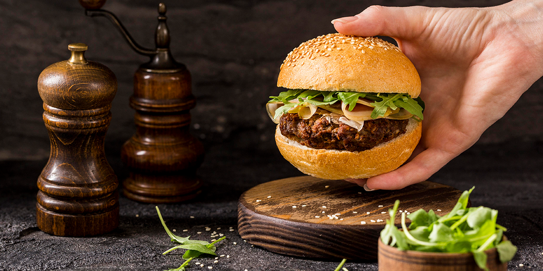 A burger being held in a hand.