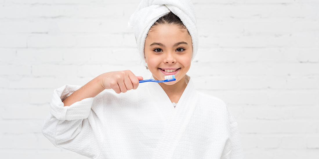 A child brushing his teeth with a ClassicGold Kids Toothbrush.