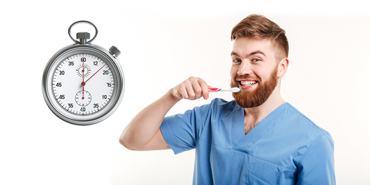 A man holding a toothbrush, demonstrating a two-minute oral health routine: brushing for two minutes, using fluoride toothpaste, covering all tooth surfaces, and rinsing thoroughly.